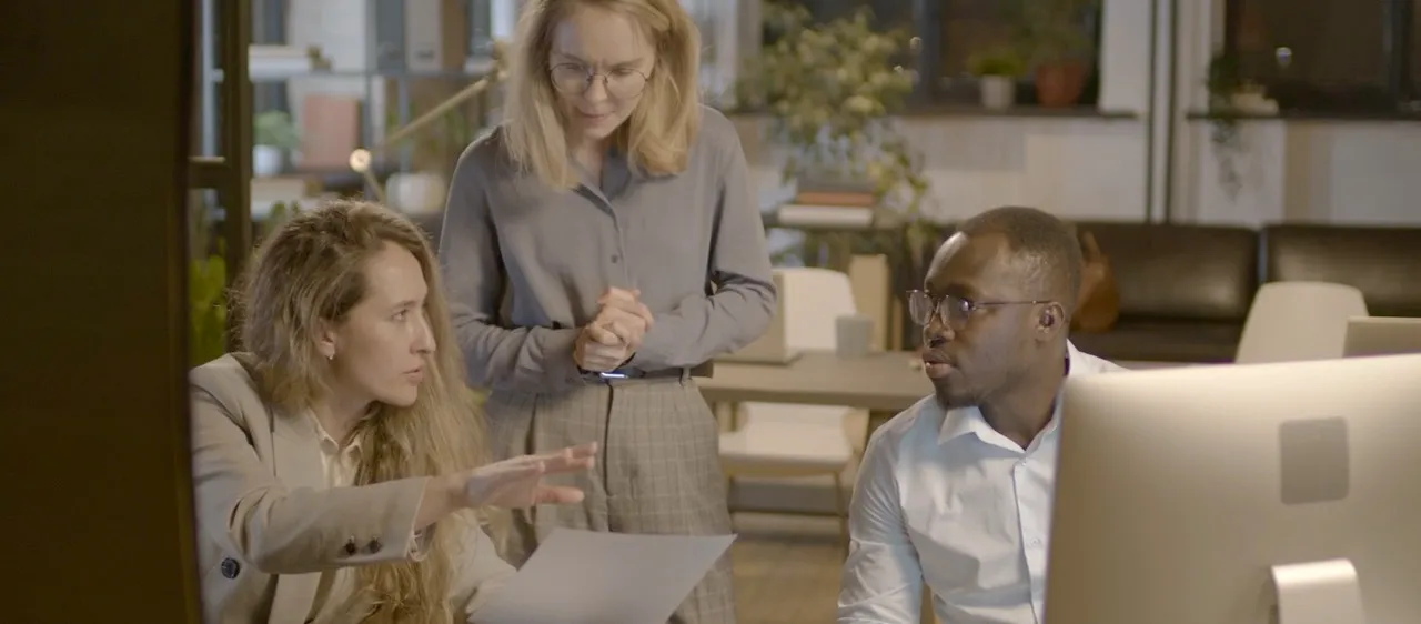 Three advisers working through a client file together around one screen.