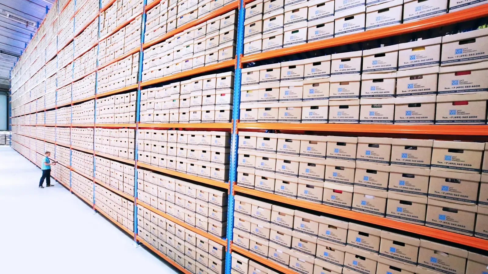 Rows of numbered archive boxes on warehouse shelving, receding into the distance