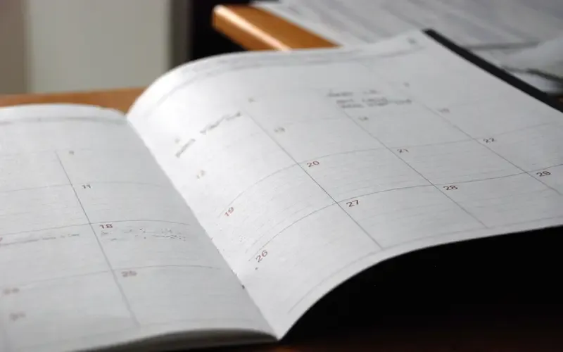 An open month-to-view paper planner on a desk