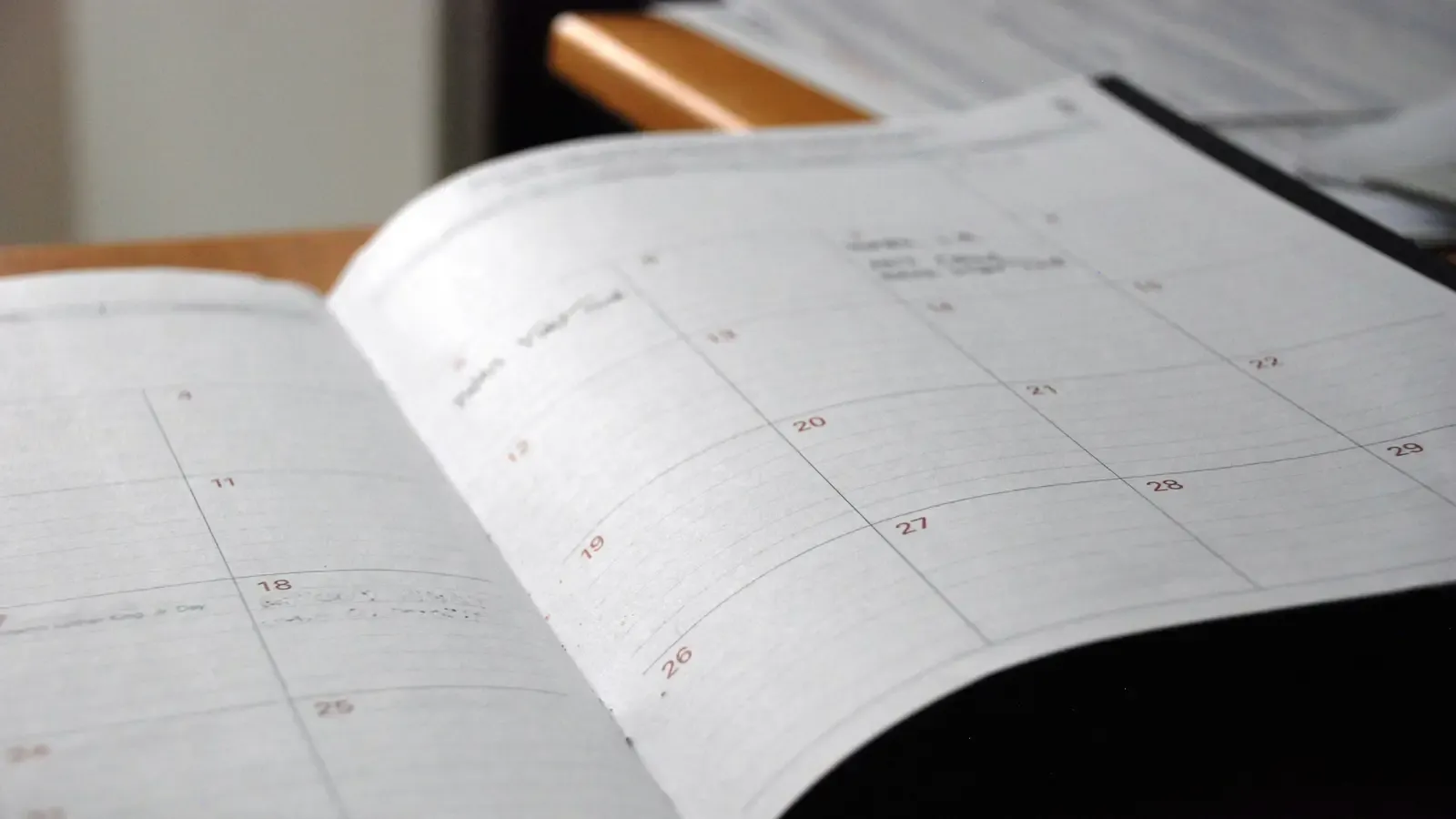 An open month-to-view paper planner on a desk