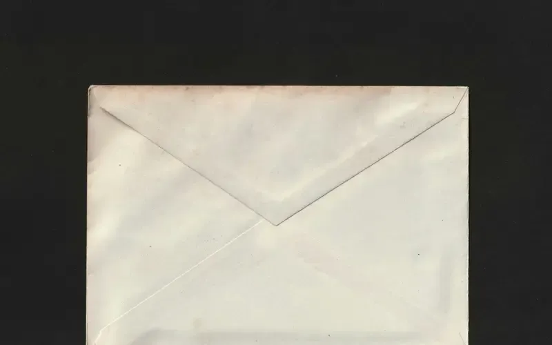 A single sealed white envelope on a black surface